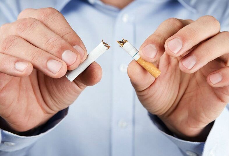Un home rompe un cigarro